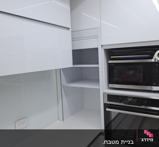 מטבח מודרני עם ארונות לבנים ותנור בילד אין